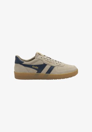 Zapatilla deportiva de ante beige con rayas azul marino, suela de goma y el logo "Gola" en el lateral, vista desde el perfil izquierdo.