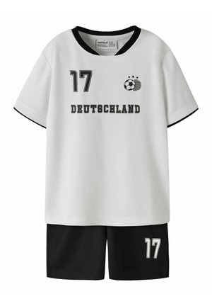 Tenue de sport blanche et noire avec le numéro 17, graphique de ballon de football et texte "Deutschland" sur le maillot, associée à un short noir.
