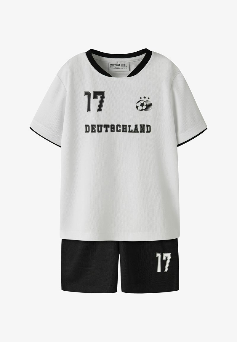 Tenue de sport blanche et noire avec le numéro 17, graphique de ballon de football et texte "Deutschland" sur le maillot, associée à un short noir.