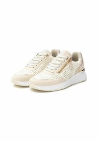 Zapatillas con una parte superior de cuero blanco perforado, detalles en crema, cremallera dorada, cordones planos y una suela blanca acolchada.