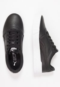Black leather sneakers with textured surface, white rubber sole, and padded collar. Features black laces and logo on the tongue.