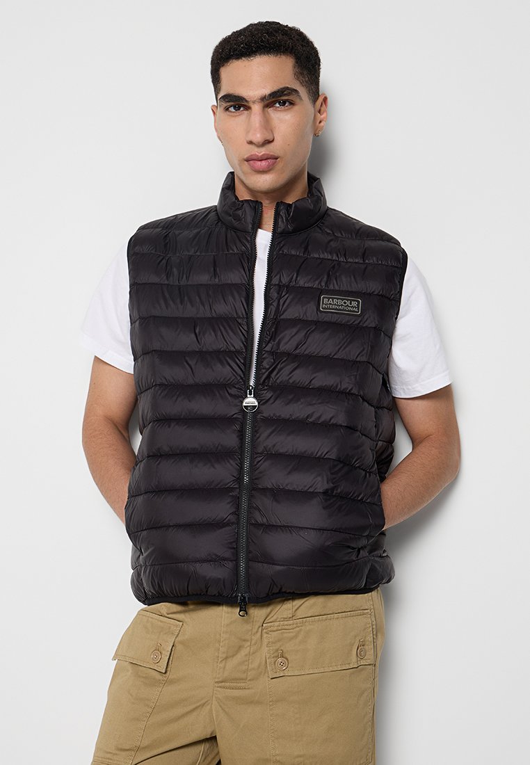 Schwarze gepolsterte Weste mit hohem Kragen, horizontal gestepptem Design und einem Front-Reißverschluss. Verfügt über ein kleines Logopatch auf der Brust. Lässige Passform.