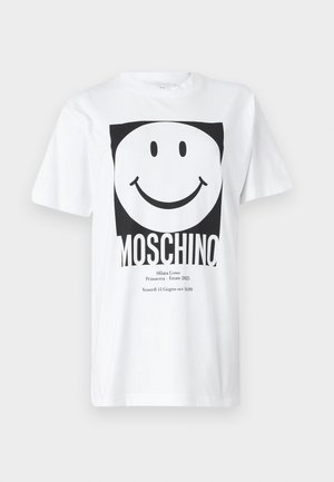 Bílá bavlněná tričko s černým čtvercovým grafickým motivem usmívající se tváře a textem "MOSCHINO" dole. Krátké rukávy, kulatý výstřih.