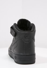 Czarne, wysokie trampki z gładkiej skóry, z wyściełanym kołnierzem, zapięciem na rzep, teksturowaną gumową podeszwą i wytłoczonym logo.