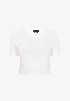 Weißer kurzärmliger Pullover mit geripptem Saum, der ein Paillettenmuster auf der Vorderseite für Struktur und Glanz aufweist. Größenetikett innen sichtbar.