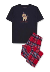 Granatowa koszulka z grafiką psa i napisem "Pomocnik Świętego Mikołaja", w połączeniu z czerwonymi spodniami dresowymi w kratę z niebieskimi i białymi liniami.