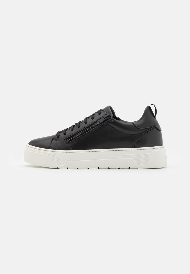 Baskets basses noires avec semelle blanche épaisse, fermeture éclair latérale, lacets et languette au talon, vues de l'extérieur.