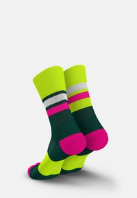 Bunte Socken mit grünen, neon-gelben, pinken und weißen Streifen. Hergestellt aus einem strukturierten Material mit kontrastierenden Zehen- und Fersenakzenten.