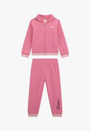 Zachte set van een roze sweatshirt en broek. Voorzien van een ritssluiting hoodie, gestreepte boorden en het 'Guess' logo op zowel de jas als de broek.