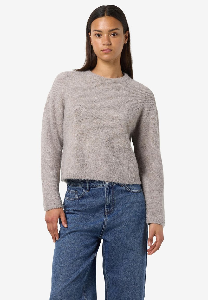 Pulover scurt, gri deschis, cu guler rotund și mâneci lungi, realizat dintr-un material tricotat texturat; asociat cu blugi albastri cu talie înaltă.