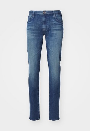 Jeans de mezclilla azul para hombre con corte recto, que presentan un diseño clásico de cinco bolsillos, un sutil desgastado y un cierre de botón metálico.