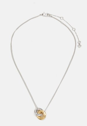Silver chain necklace with two interlocking smooth rings, one gold and one silver, on a white background.