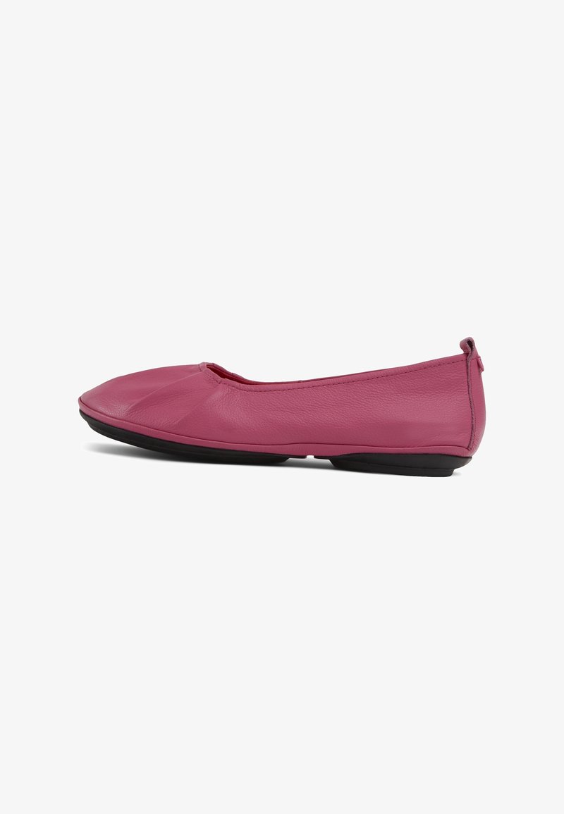Chaussure plate en cuir rose doux avec bout rond, légère fronce devant et semelle noire, vue de profil gauche.