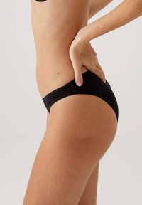 Zwarte bikini slipjes gemaakt van gladde stretchstof, met een lage taille en een minimalistisch ontwerp met gebogen naden.
