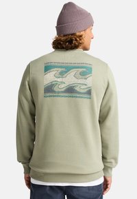 Mintgroene sweatshirt met een golfgraphic in blauw en beige op de achterkant, met ribgebreide manchetten en zoom. Zachte katoenen stof.