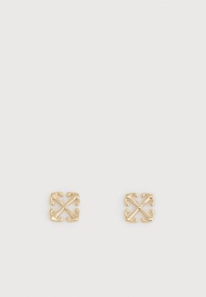 Deux petites boucles d'oreilles carrées en or avec un motif symétrique, orné et ajouré sur fond blanc.