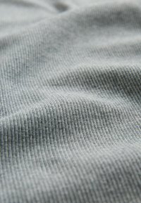 Tissu gris clair côtelé avec des plis subtils, montrant de fines lignes verticales et une texture douce.