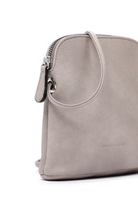 Graue Wildleder-Crossbody-Tasche mit glatter Textur, silbernem Reißverschluss und einem eingeprägten Logo auf der Vorderseite. Verfügt über einen einzelnen Schultergurt.