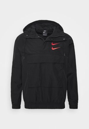 Black Nike hooded windbreaker with front pocket, elastic cuffs and hem, and two red Nike swoosh logos on the chest.