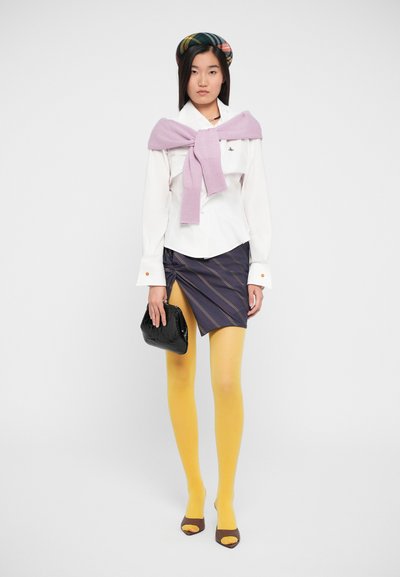 Witte blouse met parelknopen, lila sjaal, marineblauwe gestreepte minirok, gele panty en zwarte textuur clutch. Bruine open teen hakken.