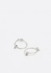 Pendientes de aro plateados con acentos en forma de corazón, que presentan un acabado pulido y un diseño ligero. Simples y minimalistas en estilo.