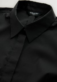Zwarte shirt met een klassieke kraag, gemaakt van gladde stof. Heeft een knoopsluiting en een subtiele glans, ontworpen voor een moderne pasvorm.