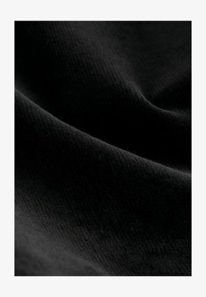 Mustaa kangasta, jossa on pehmeä ja teksturoitu pinta. Materiaalissa on hienovaraisia raitoja ja lempeä kiilto, joka korostaa syvyyttä ja lämpöä.