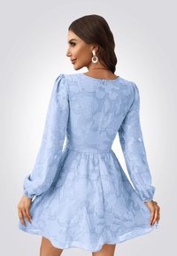 Robe bleu clair avec de longues manches bouffantes, motif floral texturé, corsage ajusté, jupe évasée et détail de fermeture éclair discrète au dos.