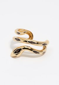 Pulsera de brazo en forma de serpiente de color dorado con superficie lisa y brillante. Presenta acentos ovalados negros a lo largo del cuerpo. Diseño de extremos abiertos.
