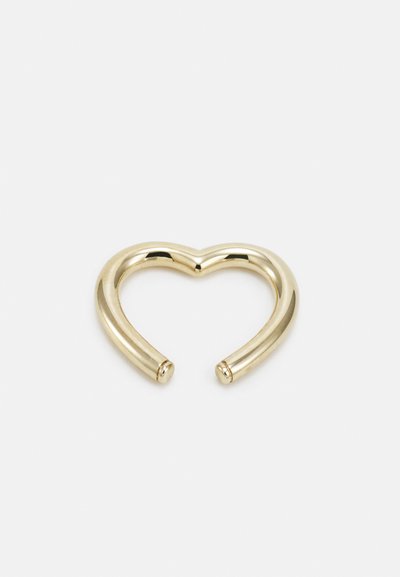Anello a forma di cuore in metallo color oro, con una superficie liscia e lucida e estremità arrotondate, caratterizzato da un design unico e aperto.