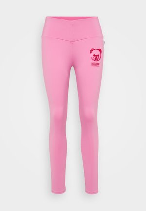Collants roses en matériau lisse et extensible. Présente un logo d'ours et le texte de la marque en rouge sur la hanche gauche. Conception à taille haute.