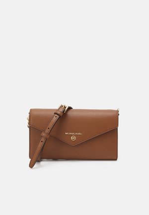 Brown leather Michael Kors crossbody bag with adjustable strap and gold logo on front flap against white background.
