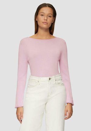 Lichtroze top met lange mouwen en een brede halslijn, gemaakt van zachte, geribde stof. Gecombineerd met off-white high-waisted jeans.