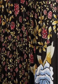 Schwarzer Stoff mit einem floralem Muster, das rosa Rosen und grüne Blätter zeigt, kombiniert mit blauen und gelben Akzenten; durchgehend plissierte Textur.