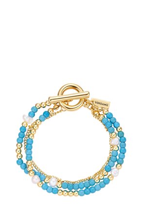 Bracciale con perline d'oro e turchese, perle d'acqua dolce e chiusura toggle incisa con "YOKOAMii", disposto su più fili.