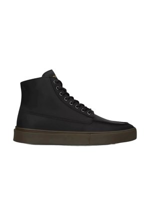 Zapatilla deportiva alta de cuero negra con cordones negros y suela gruesa de goma marrón oscura, vista lateral sobre fondo blanco.