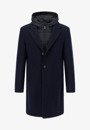 Marineblå uldfrakke med aftagelig sort hætteforet inderfor, to forlommer og enkelt knappelukning. Jævn tekstur over det hele.