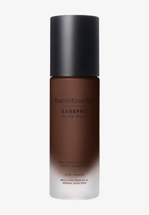 Bottiglia di vetro marrone con tappo nero opaco. L'etichetta riporta "bareMinerals" e "BAREPRO 24 HR WEAR" con testo bianco. Fondotinta liquido all'interno, semi-trasparente.