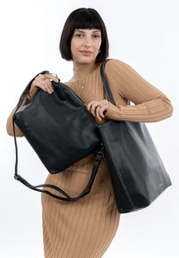 Tote et sacs à bandoulière en cuir noir avec une finition texturée ; les deux présentent des détails de couture et des sangles ajustables pour plus de polyvalence.