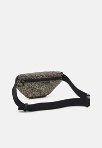 Zwart en goudkleurige heuptas met een plat, driehoekig ontwerp, ritssluiting en verstelbare riem. Afgewerkt met een textuurstof.