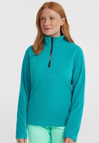 Pullover in pile turchese con zip a metà e zip nera. Caratterizzato da maniche lunghe e una finitura testurizzata. Logo nella zona della zip.