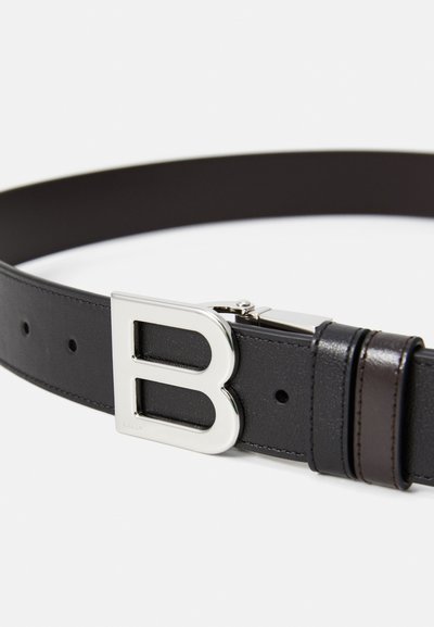 Curea din piele neagră cu o cataramă metalică argintie în formă de literă "B". Catarama are un finisaj strălucitor și dispune de un mecanism de prindere.