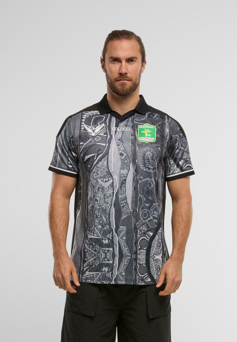 Fekete és szürke mintázatú pólóing gallérral, absztrakt mintázatokkal és zöld emblémával a mellkasán. Rövid ujjak és testhez simuló fazon.