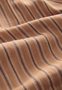 Tejido marrón a rayas con líneas horizontales en crema y azul oscuro. La textura parece suave y ligeramente texturizada, con un aspecto de tejido natural.