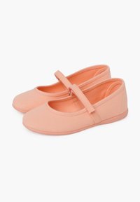 Zapatillas de lona color durazno con punta redondeada, correa en el empeine y suelas de goma. Diseño simple, textura mínima y acabado suave.
