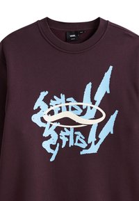 Felpa di colore viola scuro con un audace design grafico blu chiaro caratterizzato da forme e linee astratte. Il collo è di stile classico a girocollo.
