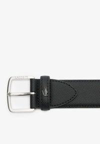 Cinturón de tela negra con hebilla metálica plateada, que presenta una superficie texturizada, detalle del logo y acentos de cuero. Tamaño ajustable con diseño clásico.