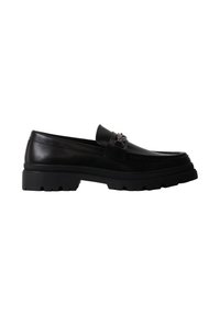 Mocassin en cuir noir avec semelle épaisse crantée et détail décoratif en métal sur le dessus, vu de profil sur fond blanc.
