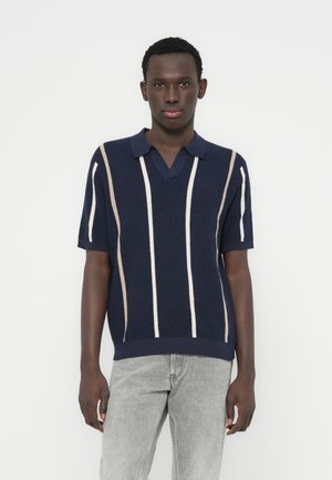 Polo de punto azul marino con mangas cortas, con rayas verticales en beige y blanco, escote en v y acabado texturizado.