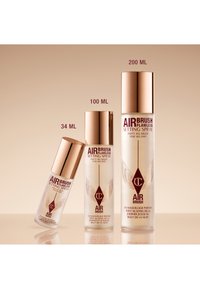 Airbrush Flawless Setting Spray bottles in three sizes: 34 ML, 100 ML, and 200 ML. Clear glass, gold caps, and white text with logos.